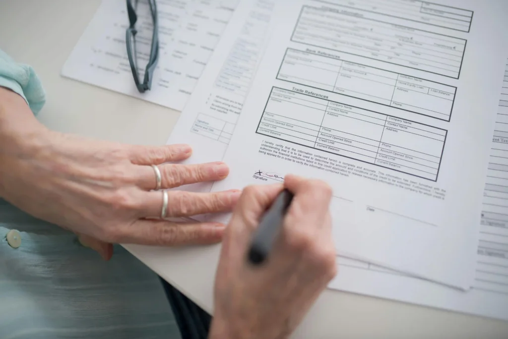 Persona firmando documentos para tramitar la dependencia en 2026